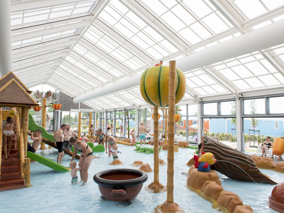 Kinderen spelen in de overdekte waterspeeltuin met speeltoestellen en fonteintjes op Vakantiepark Eiland van Maurik.