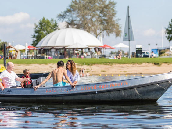 Gezin geniet van een boottocht in een sloep op de recreatieplas bij Vakantiepark Eiland van Maurik.