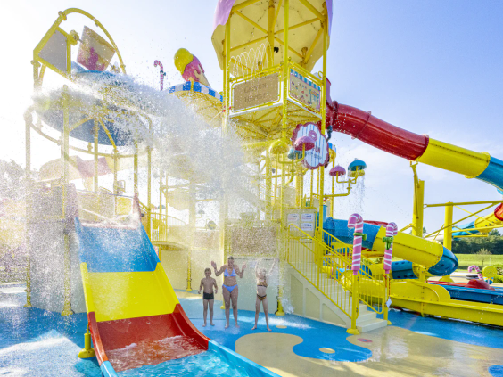 Een enorme emmer water kiept om over spelende kinderen in het waterpark