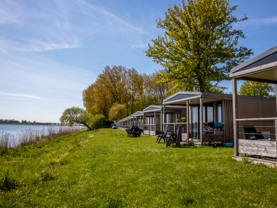 Uitzicht vanaf het terras op het groene gras en het strand in de verte