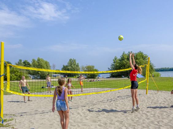 Jongeren spelen beachvolleybal op het zandstrand van Capfun Erkemederstrand