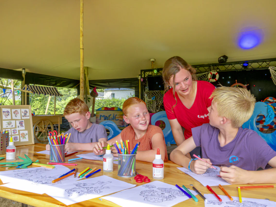 Kinderen maken knutselwerken in de overdekte animatieruimte