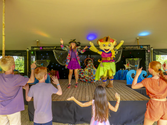 Kinderen dansen mee met de mascottes tijdens de avondshow