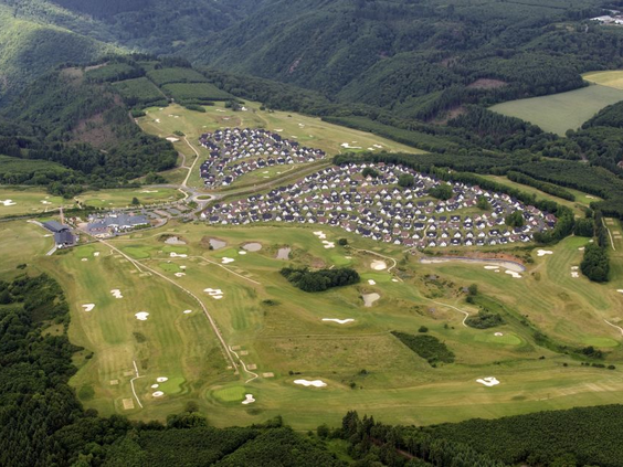 Een luchtfoto van het uitgestrekte Ferienresort Cochem, gelegen tussen de groene heuvels en de golfbanen van de Moezelstreek.