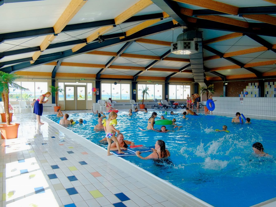 Het overdekte binnenzwembad van Ferienresort Cochem vol met spetterende en zwemmende kinderen en hun families.