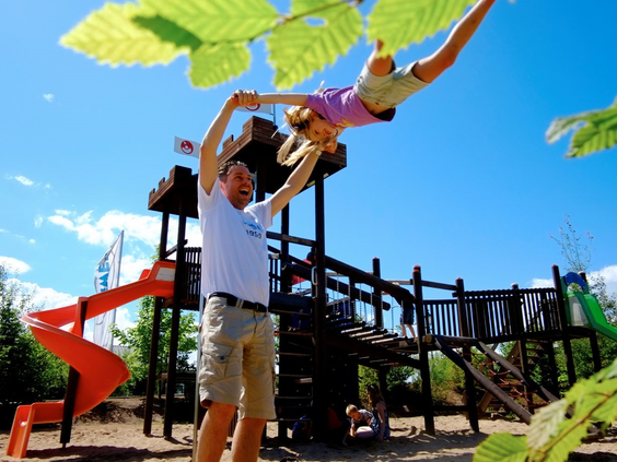 Kinderen spelen in de buitenspeeltuin met klimtoestel en glijbaan op Ferienresort Cochem aan de Moezel in Duitsland