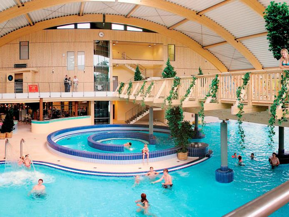 Het grote subtropische zwemparadijs Brockenbad op Vakantiepark Hasseröder, met een stroomversnelling en veel zwemmende gasten.