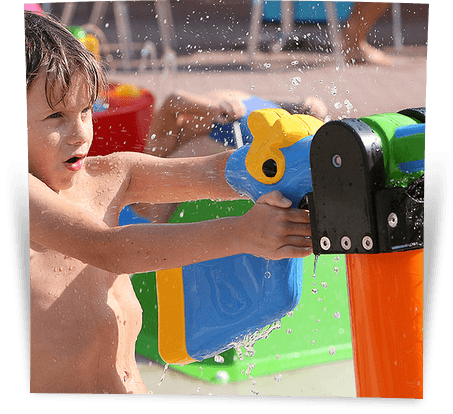 Een jongen heeft waterpret en spuit met een groot waterkanon in het waterspeelpark van Aquaventura Hellendoorn.