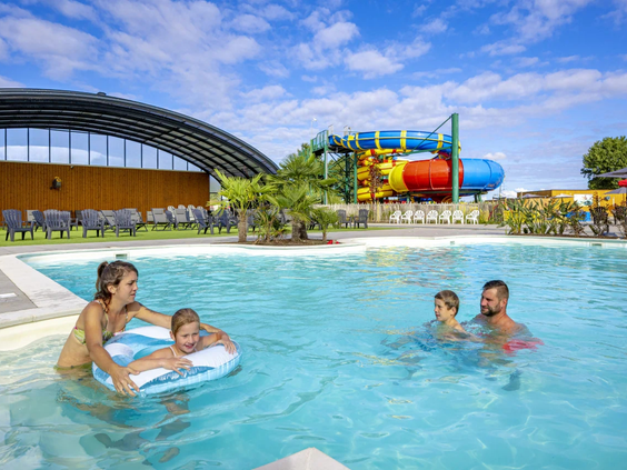 Een vader en kinderen hebben plezier in het verwarmde zwembad van het park