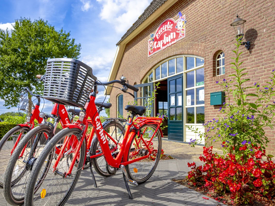 Rode huurfietsen staan klaar bij het verhuurpunt van camping de IJsselstrand