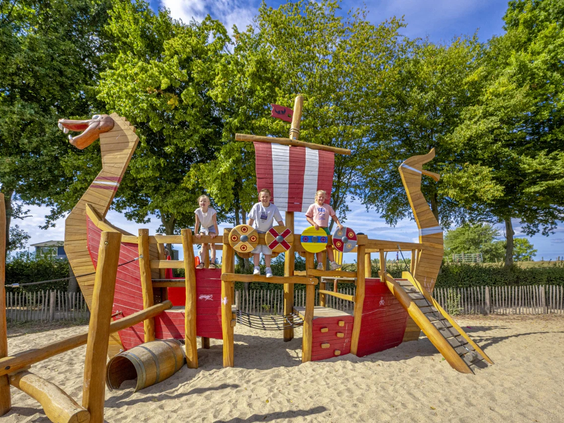 Detail van het houten piratenschip speeltoestel met vlaggen