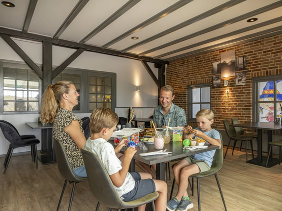 Het sfeervolle interieur van het restaurant met houten balken en gedekte tafels