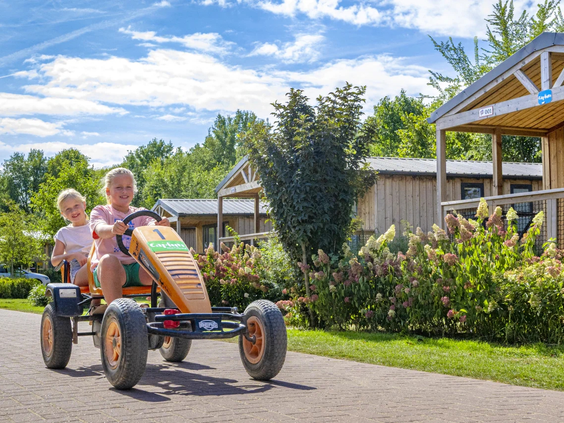 Een gezin rijdt op een grote gehuurde familiefiets over het park