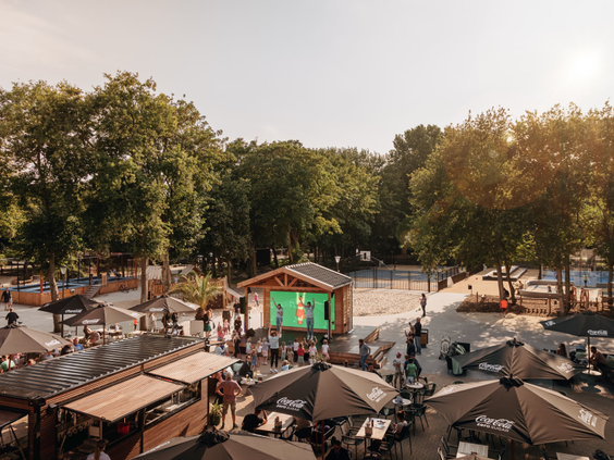 Overzicht van de levendige centrale plaza op Vakantiepark Kijkduin, met zonnige terrassen, horeca en veel gezelligheid in de duinen.