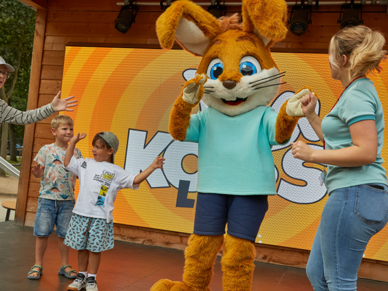 Kinderen dansen en zingen samen met de vrolijke parkmascotte Koos Konijn op het podium bij Vakantiepark Kijkduin.