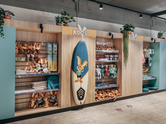 De parkwinkel van Vakantiepark Kijkduin met schappen vol speelgoed, souvenirs en een surfplank van Koos Konijn.