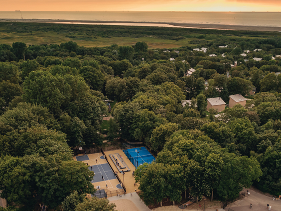 Luchtfoto van Vakantiepark Kijkduin, prachtig gelegen in een groen duinlandschap, vlak bij de Noordzeekust in Zuid-Holland.