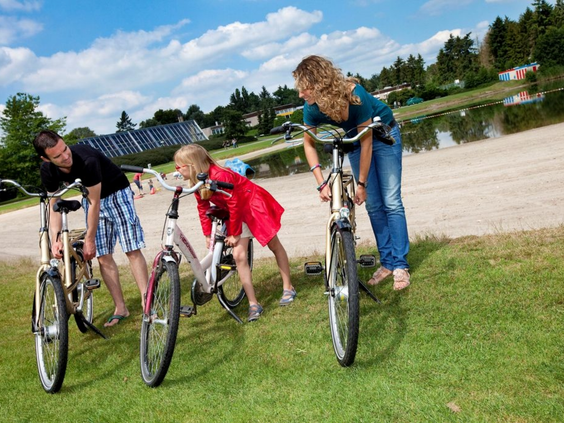 Gezin maakt zich klaar voor een fietstocht langs het water op Vakantiepark Klein Vink in Arcen.
