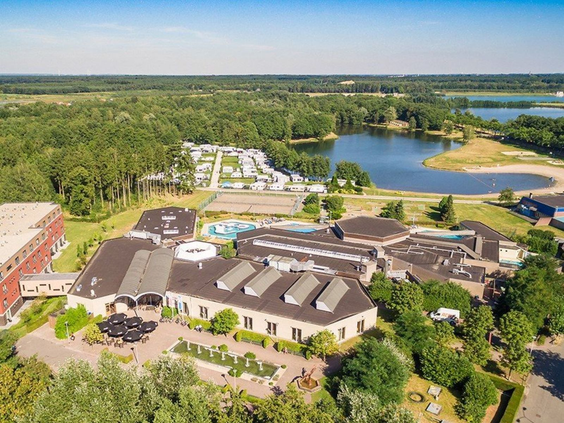 Luchtfoto van Roompot Vakantiepark Klein Vink met het centrale gebouw, het thermaalbad, het recreatiemeer en de camping.