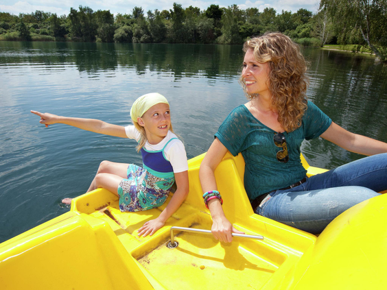 Moeder en kind op een gele waterfiets op het recreatiemeer van Vakantiepark Klein Vink in Arcen.