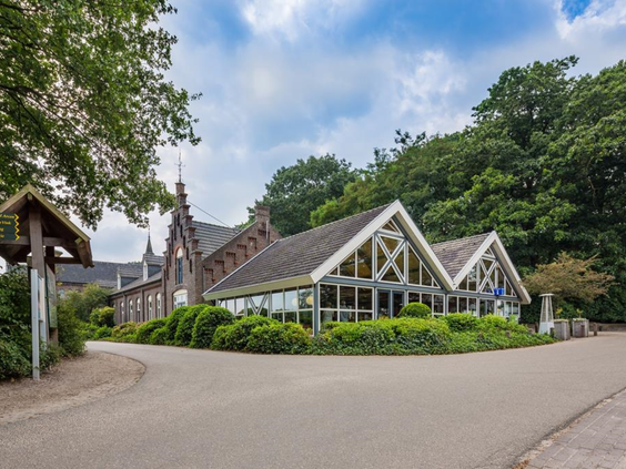 Het hoofdgebouw van Vakantiepark Klein Vink in Arcen, gelegen tussen het groen.