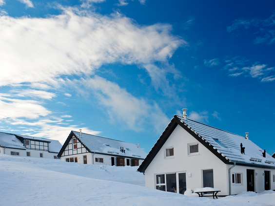 De vrijstaande chalets van Landal Winterberg liggen onder een dik pak sneeuw, klaar voor een wintervakantie.