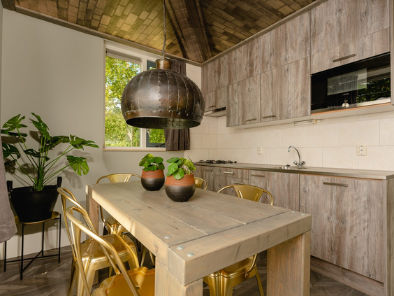 Het stijlvolle interieur van een Regge Lodge op Vakantiepark Molke, met een houten eettafel en moderne keuken.