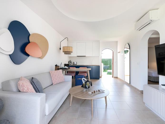 Het interieur van een ruime bungalow bij Parque Cristobal met een gezellige zithoek, moderne kunst en een handige kitchenette.