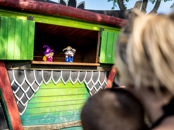 Kinderen kijken naar een poppenkastvoorstelling op de camping