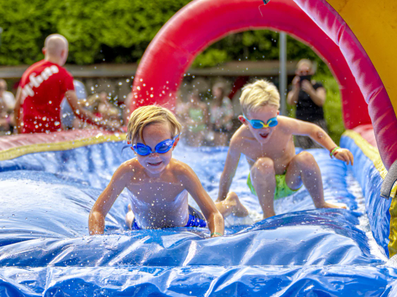 Peuters spelen in een ondiep opblaasbaar zwembadje op het park