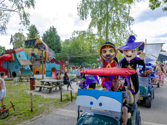 Vrolijke parade met mascottes en het animatieteam op het vakantiepark
