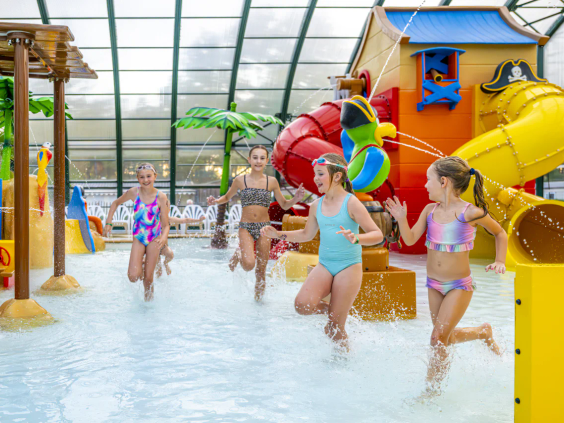 Kinderen spelen in het overdekte kinderbad met interactieve waterspeeltoestellen