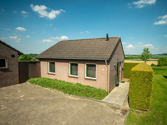 Vrijstaand vakantiehuis op Vakantiepark Reevallis met een terras en vrij uitzicht over de Limburgse velden.
