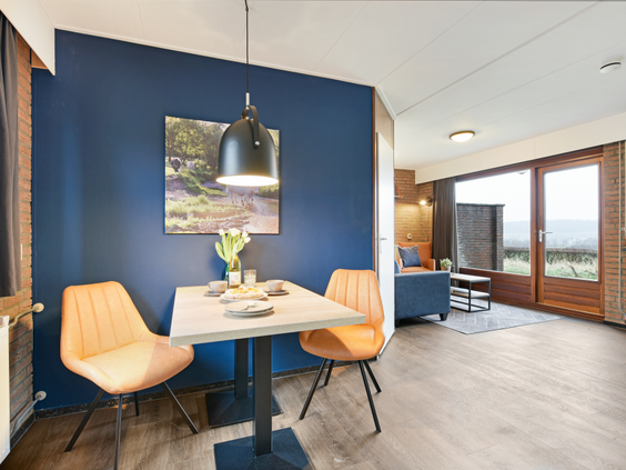 Sfeervol ingerichte eethoek en zithoek in een bungalow op Vakantiepark Reevallis in Limburg.