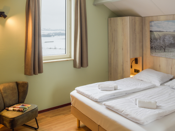 Nette slaapkamer met comfortabele, opgemaakte bedden in een vakantiewoning op Vakantiepark Reevallis.