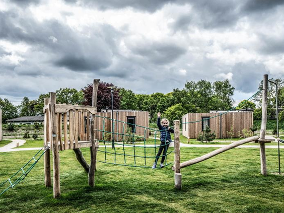 Avontuurlijke buitenspeeltuin met een houten klimparcours en touwbruggen op Vakantiepark Schaijk.