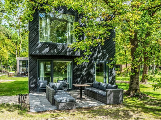 Een modern en luxe design vakantiehuis met twee verdiepingen, gelegen tussen de bomen op Vakantiepark Schaijk.