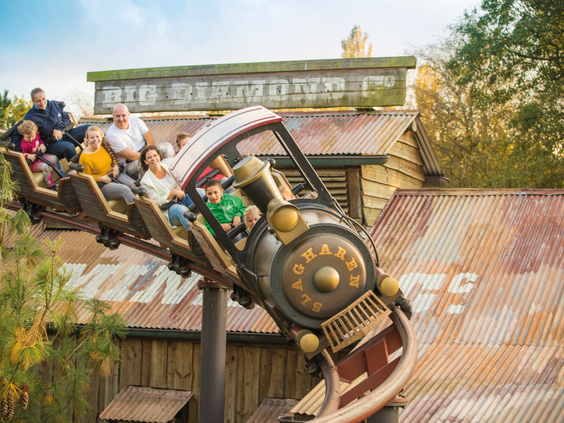 Families genieten van een rit in de Mine Train, een familie-achtbaan in de vorm van een stoomtrein in Attractiepark Slagharen.