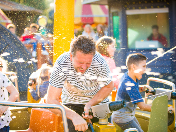 Een vader en zoon hebben een watergevecht met waterkanonnen in de attractie Expedition Nautilus in Attractiepark Slagharen.