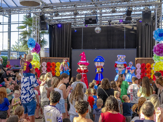 Kinderen kijken naar een spectaculaire show van het animatieteam op het podium