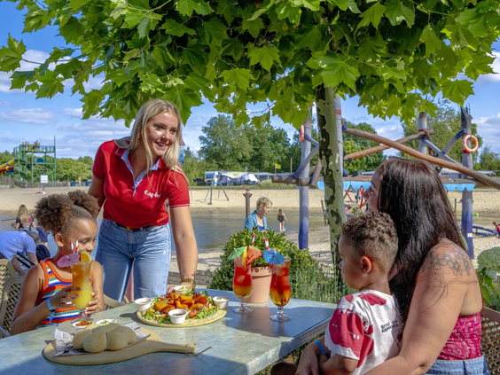 Gezin geniet van een gezamenlijke lunch in het parkrestaurant