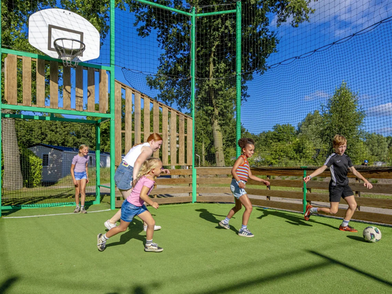 Jongeren spelen basketbal op het multifunctionele sportveld van het Stoetenslagh