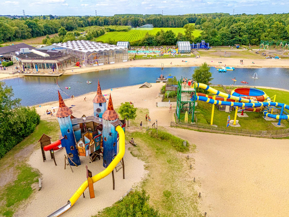 Kinderen glijden van de waterglijbanen direct het recreatiemeer in