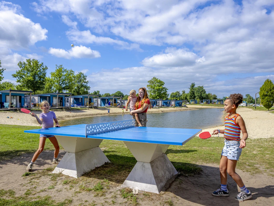 Kinderen spelen tafeltennis bij de buitenspeeltuin van de camping