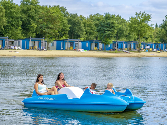 Meisjes varen in een blauw bootje op het grote meer van de camping