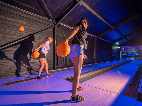Kinderen spelen een potje bowling in de overdekte plaza van het park