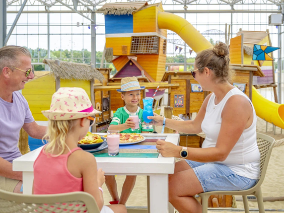Familie zit aan tafel in het restaurant van Capfun het Stoetenslagh