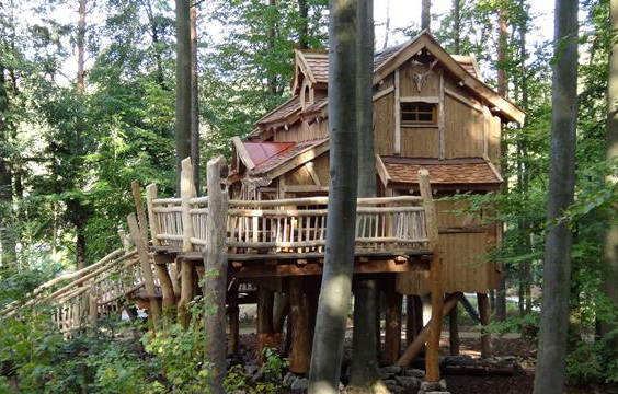 Zijaanzicht van de avontuurlijke en luxe houten boomhutten, gelegen midden in het groene bos van Vakantiepark Tripsdrill.
