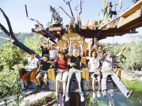 Een groep lachende mensen zwaait vanuit de 'Donnerbalken' vrije val attractie, hoog boven de grond in Erlebnispark Tripsdrill.