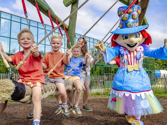 Kinderen op een nestschommel samen met de vrolijke Capfun mascotte
